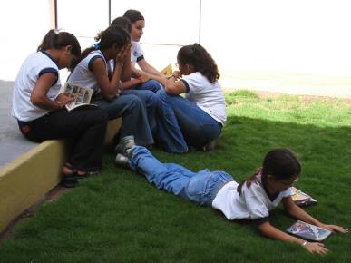 Foto de alunos conversando e lendo no ptio